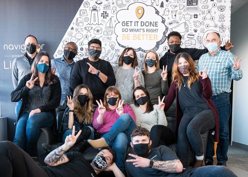 Some of the LifeRaft team standing in front of a mural wall in their Halifax office
