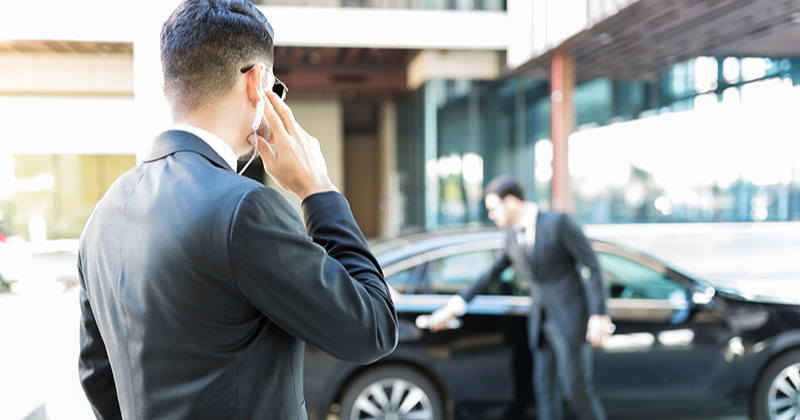 Two close protection guards escorting a VIP from a car